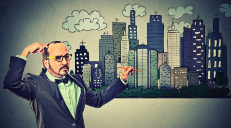 Man drawing city skyline on gray wall background. Real estate development, house market economy, investment opportunity concept